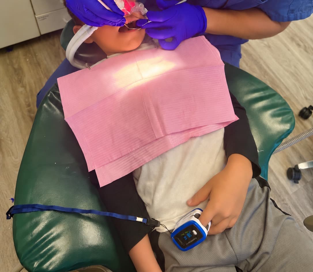 Hygiéniste donnant des soins à un enfant détendu sous gaz hilarant