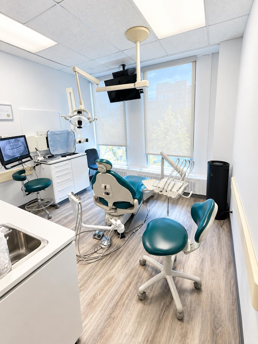 Salle de soins avec écran de radiographie et fauteuil dentaire