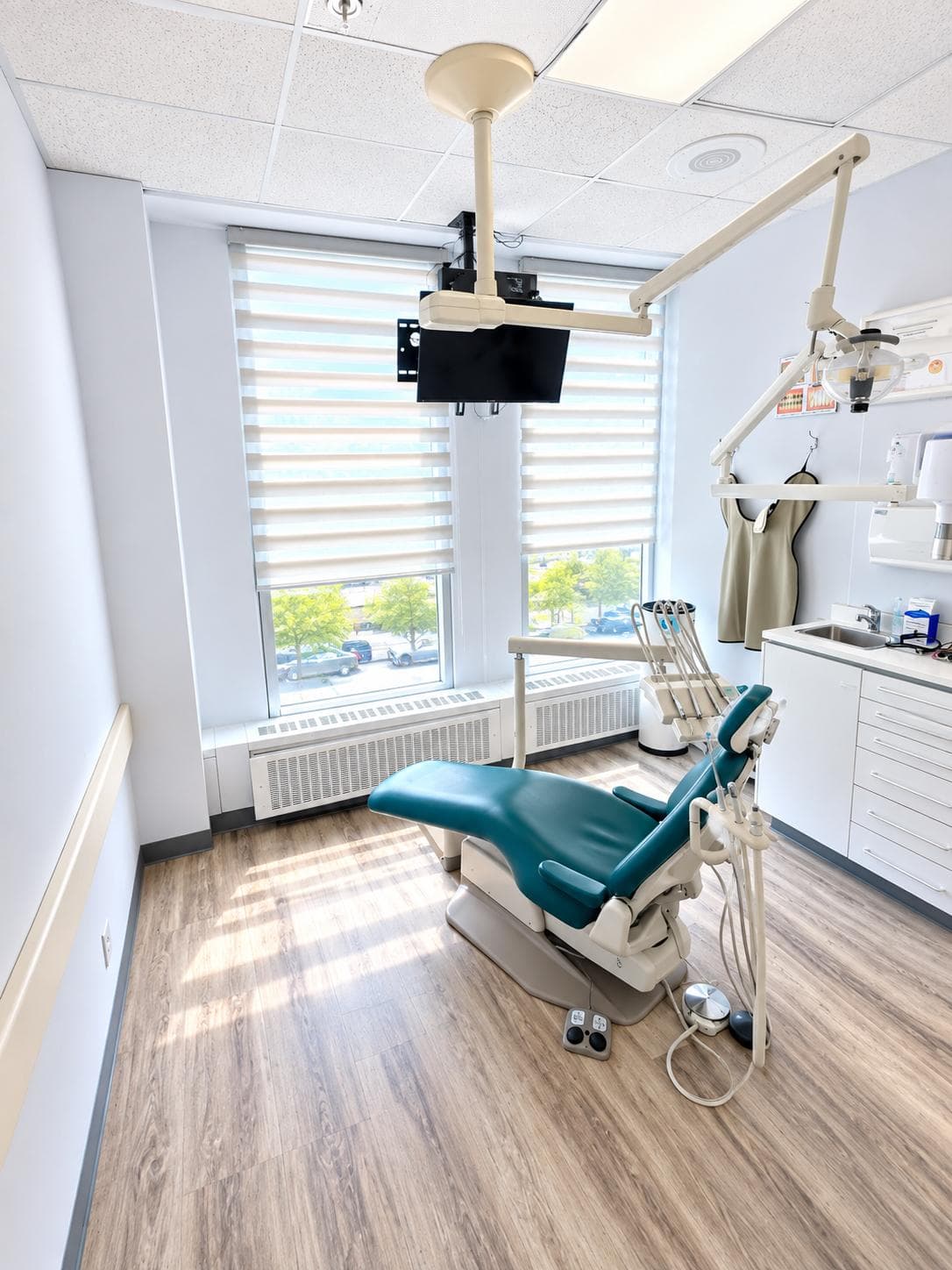 Salle de soins lumineuse avec stores et fauteuil dentaire
